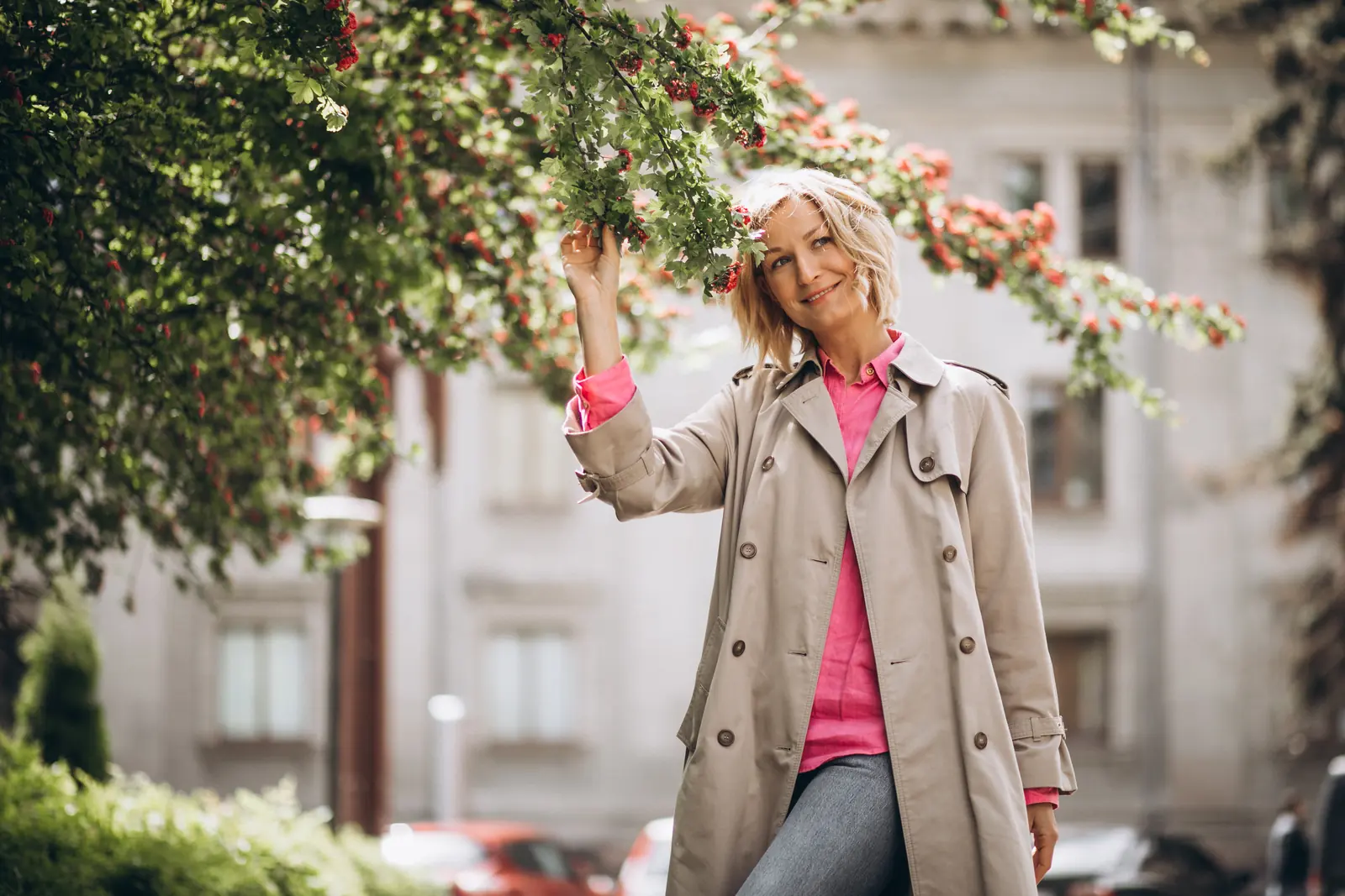 A woman standing beside flowering branches in a garden