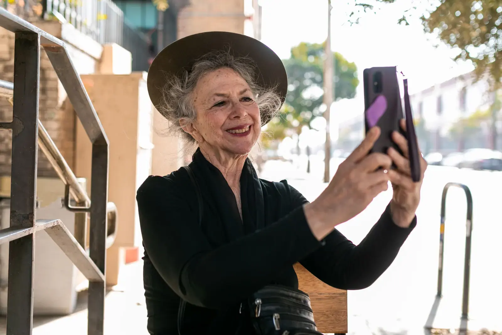 A woman holding up her phone outdoors